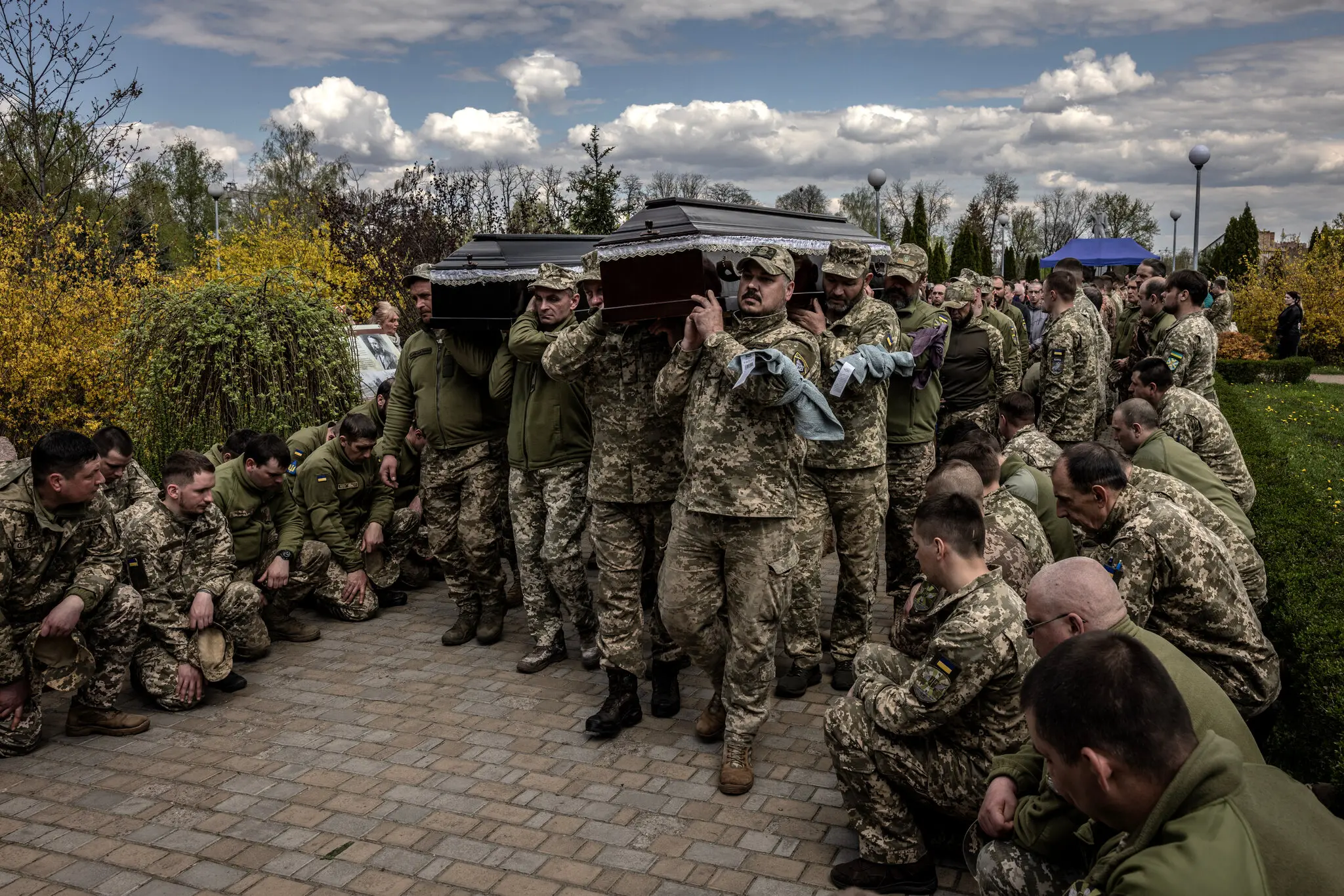 Українські воїни на колінах, як труни зі своїми загиблими товаришами, 23-річним Владиславом Посієм і 37-річним Сергієм Остапенком, які загинули осколками під час боїв на сході Донецької області, несуть під час їхнього похорону в Борисполі на Київщині 23 к